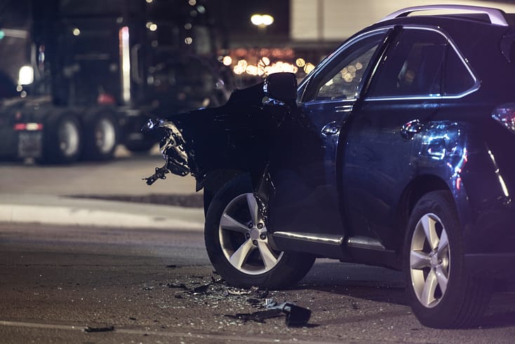 Aftermath of a serious car collision with two vehicles showing extensive damage and smoke.