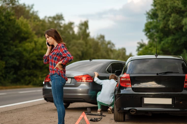 Two drivers assessing the damage to their vehicles after a traffic accident.