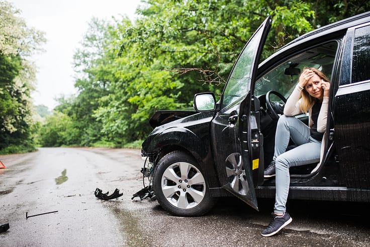 Distressed driver using phone in a wrecked vehicle after an accident.