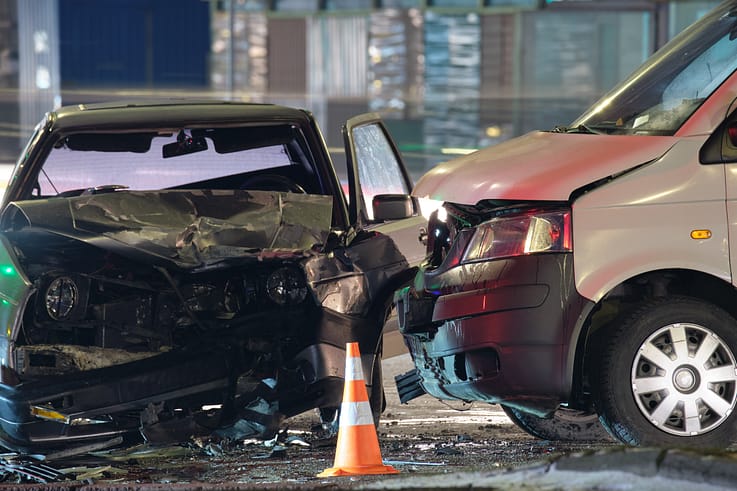 Two heavily damaged cars in a nighttime collision, illustrating the severe consequences of accidents.