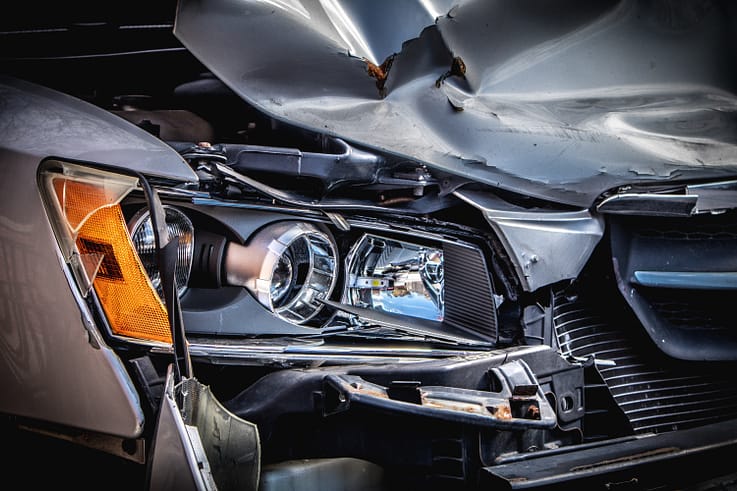 A close-up photo of a car's front end after a collision, showcasing the extensive damage.