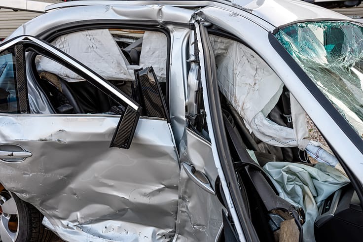 Close-up of a mangled car door after a severe collision, highlighting the impact of the crash.