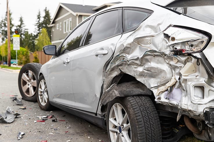 A devastating car crash scene with a heavily damaged vehicle and emergency responders in Atlanta.